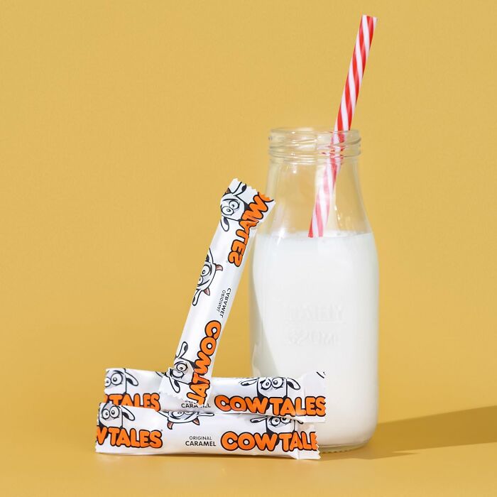 Cow Tales wrapped caramel candies leaning against a glass bottle of milk for Best Halloween Candies.