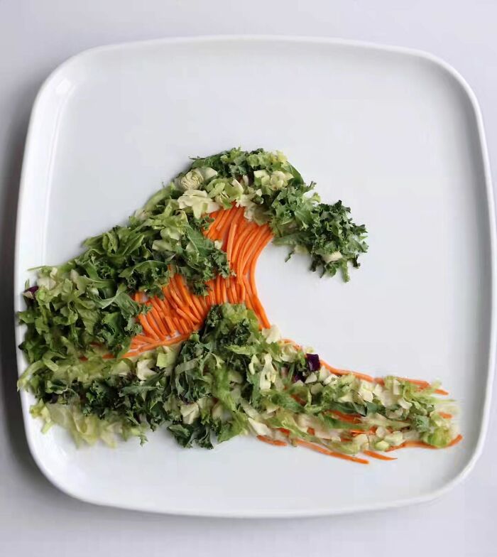 Sarah Rosado food art of a wave made from shredded green lettuce and orange carrots on a white plate.