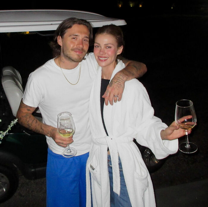 Couple posing at night holding wine glasses showing close bond Couple posing at night holding wine glasses showing close bond
