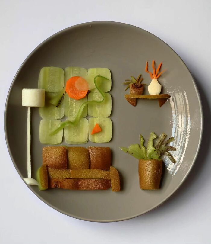 A living room setup with a couch and plants made of kiwi, portraying everyday food turned into playful works of art