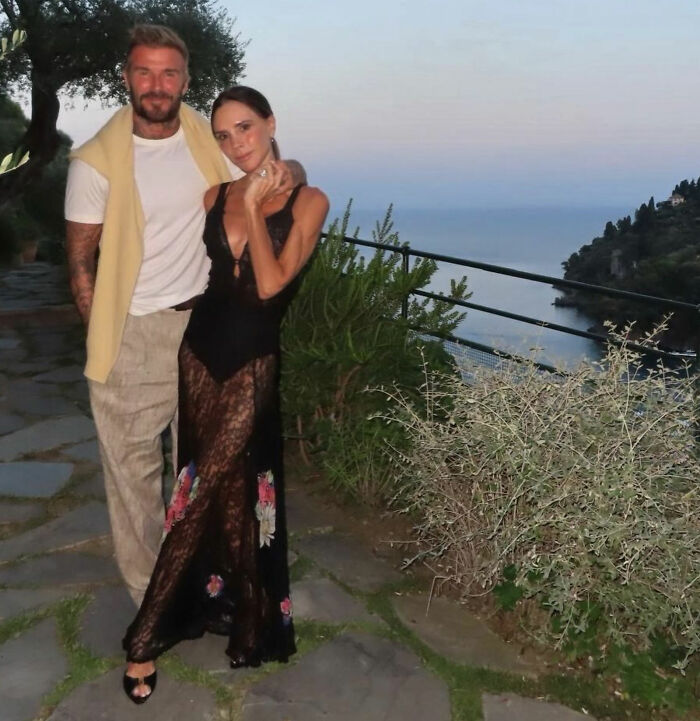 Victoria and David Beckham stand together in elegant outdoor setting Victoria and David Beckham stand together in elegant outdoor setting