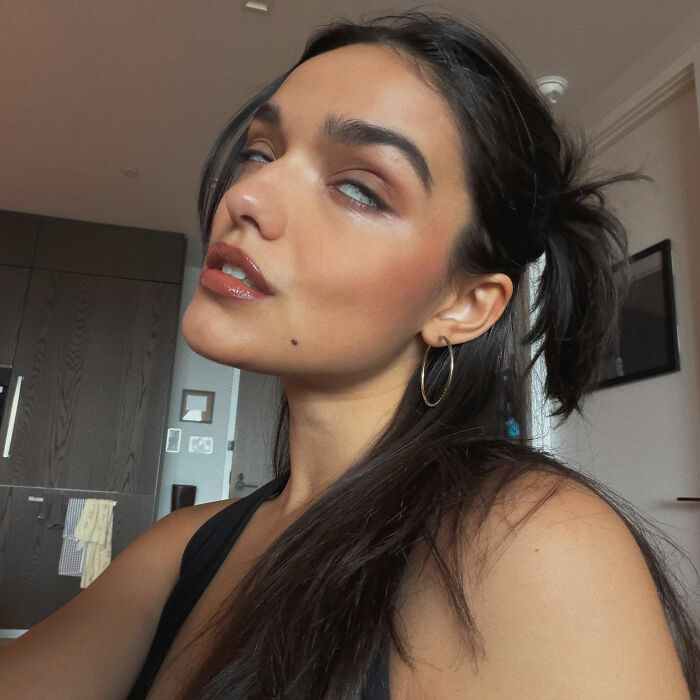 Rachel Zegler taking a selfie while making a pouty face with her eyes rolled back.