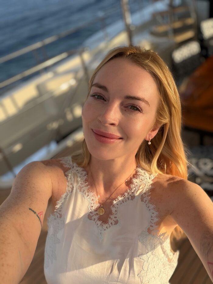 Lindsay Lohan smiling on a yacht, representing stars who got in the way of their own success.