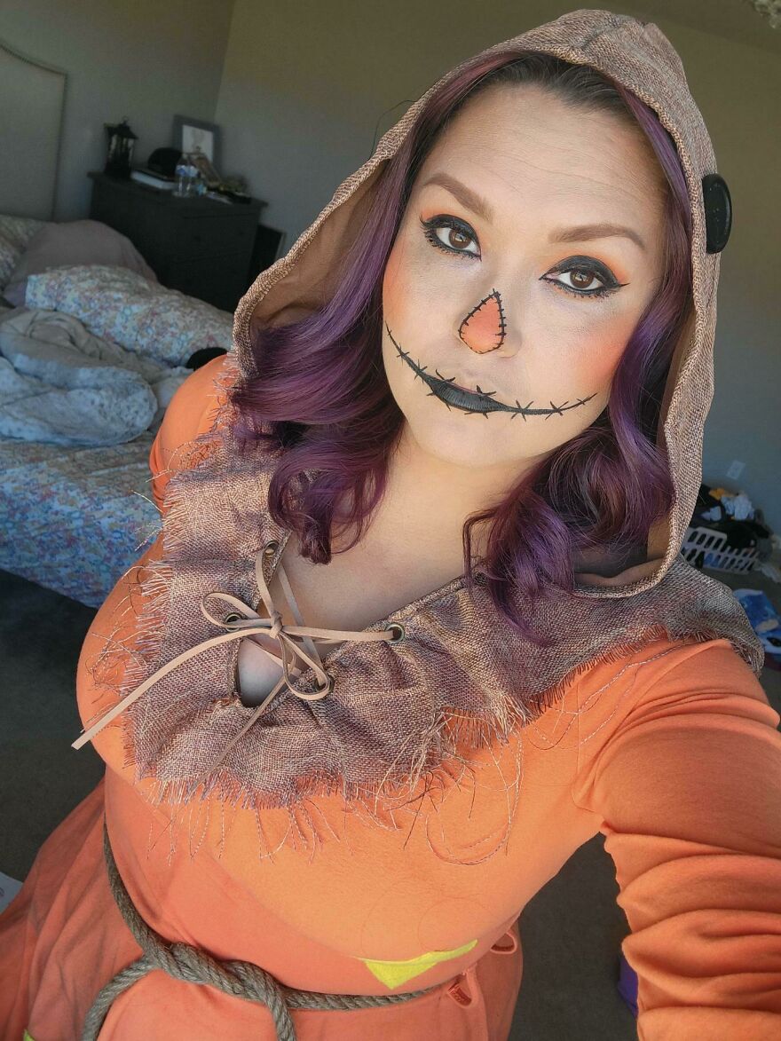 A woman with scarecrow face makeup and a hooded burlap top showcasing creative Halloween costume ideas.