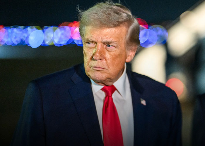 Donald Trump in a suit and red tie looking sternly to the side, following coverage of Trump waving at nobody. Donald Trump in a suit and red tie looking sternly to the side, following coverage of Trump waving at nobody.