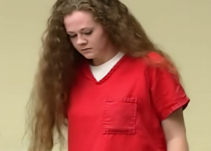Christa Pike looking down in a red prison jumpsuit, linked to discussions of her botched lethal injection