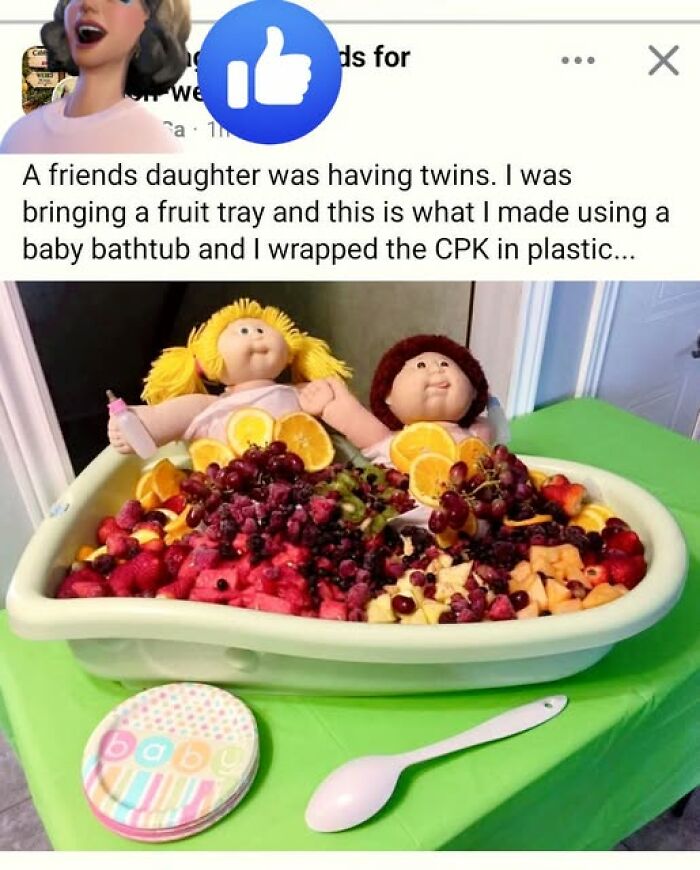 Two Cabbage Patch Kids dolls placed in a baby bathtub filled with fruit, as part of hilarious crafts.