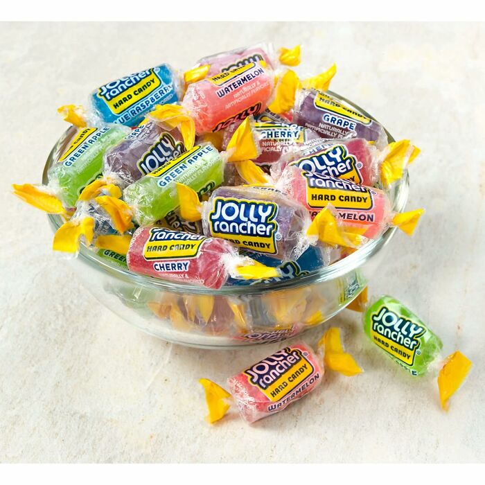 A clear glass bowl filled with colorful individually wrapped Jolly Rancher candies as Halloween Candies