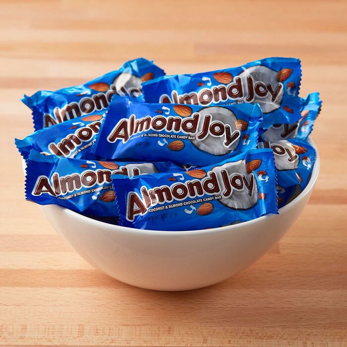 A white bowl filled with blue fun-size Almond Joy bars for Halloween candies treat lovers