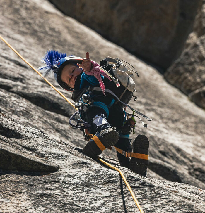 Young 7-year-old boy in climbing gear scales a steep rock wall at Yosemite's El Capitan