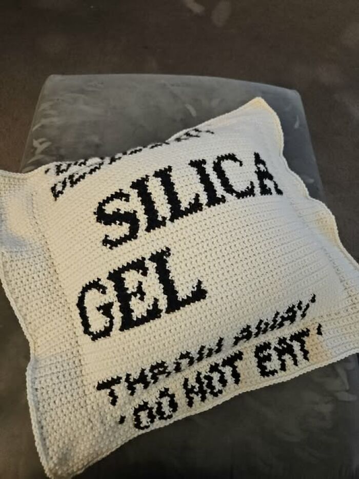 A crocheted pillow designed to look like a silica gel packet, representing creative crafts and art projects.