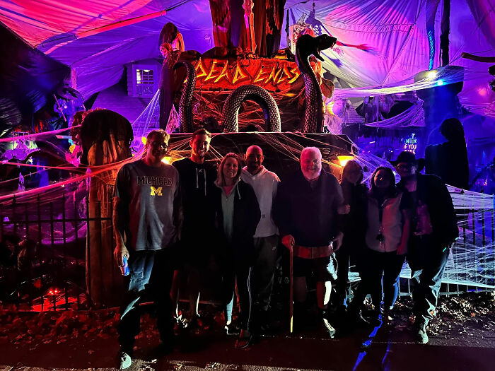 Group of people posing in front of neighborhood epic Halloween display at night Group of people posing in front of neighborhood epic Halloween display at night