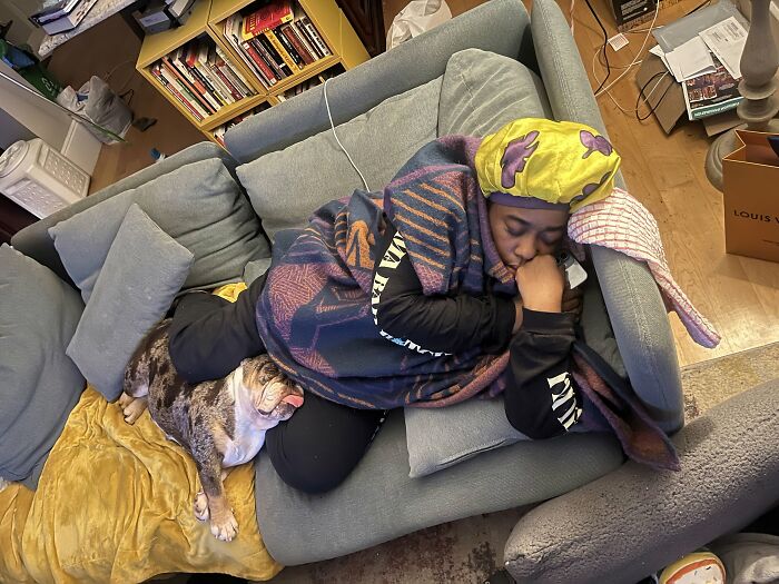 A sleeping woman and her bulldog show how pets looked so much like their owners, cuddling together on a couch