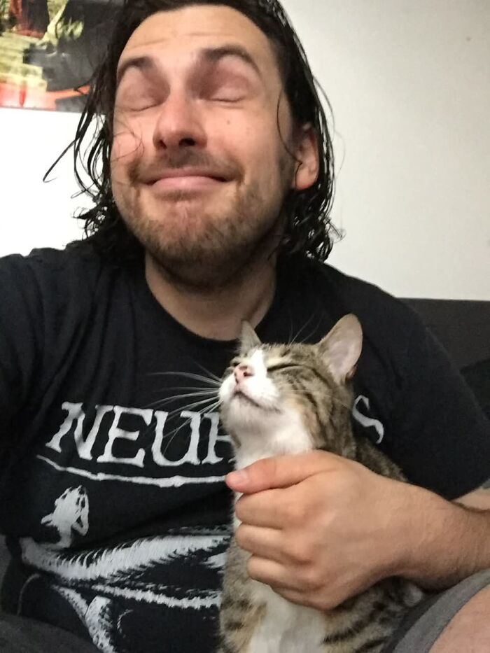 A happy man and his cat with matching blissful expressions, showing pets that look like their owners.