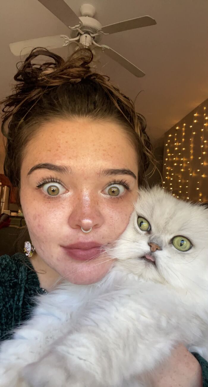 Woman and her white Persian cat showing wide green eyes, illustrating pets that look like their owners.