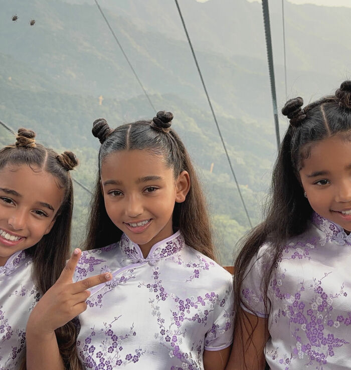 Girls in matching purple floral outfits with space buns hairstyle posing outdoors Girls in matching purple floral outfits with space buns hairstyle posing outdoors
