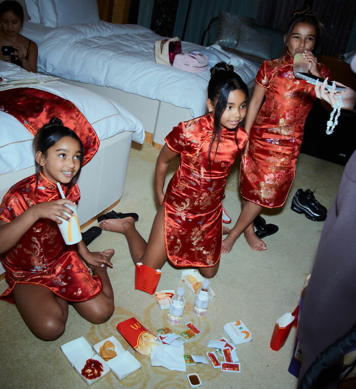 Three girls in red dresses sitting with fast food inside a bedroom Three girls in red dresses sitting with fast food inside a bedroom