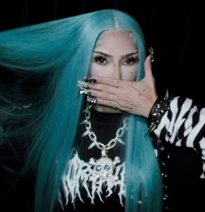 Person with teal hair covering her face during North West's Halloween transformation