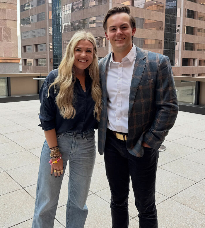Erika Kirk wearing multiple bracelets while standing next to a young man outdoors. Erika Kirk wearing multiple bracelets while standing next to a young man outdoors.