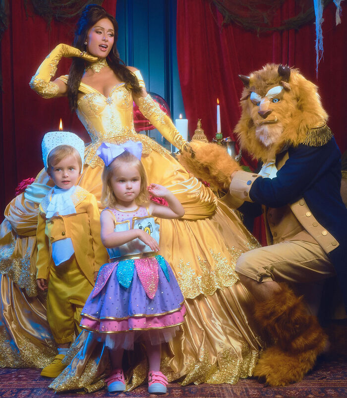 Paris Hilton posing with her husband and kids in a Beauty And The Beast costume theme.