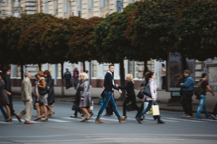 Pedestrians walking across a city street crosswalk, illustrating urban awareness and emergency tips.