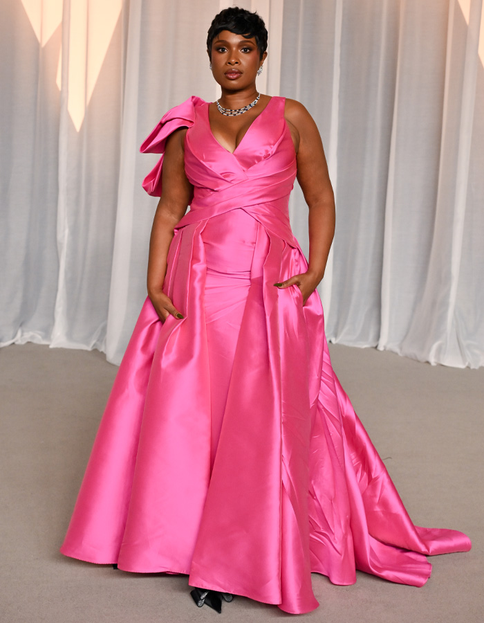 Woman in bright pink satin gown at Academy Museum Gala