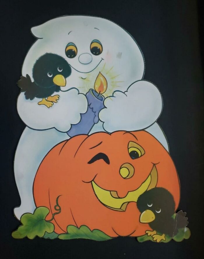Vintage Halloween paper decoration featuring a friendly ghost holding a candle and a winking pumpkin.