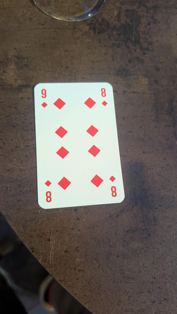 An absurd misprinted playing card showing an eight of diamonds labeled with a nine.