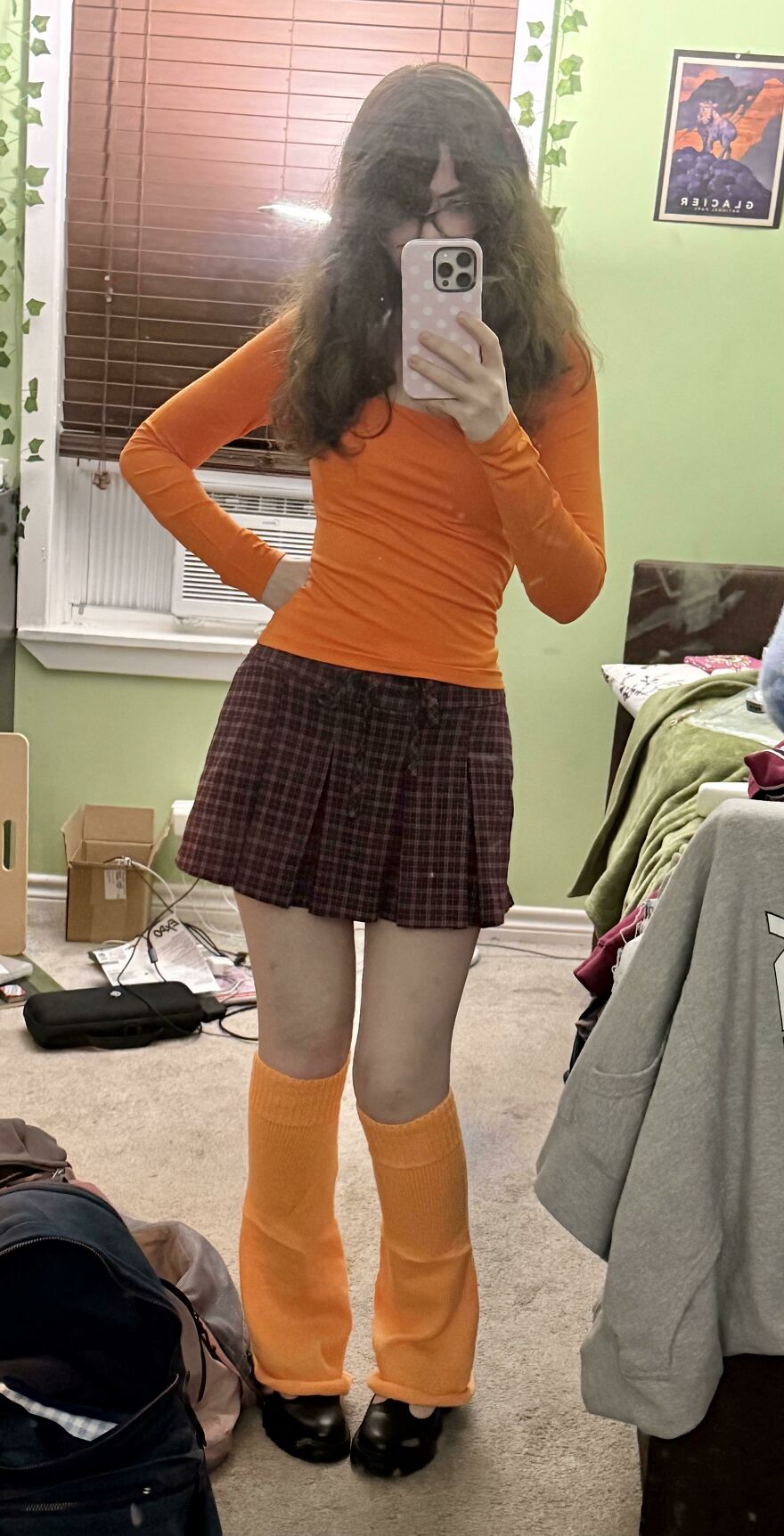 Young woman posing in a Velma-inspired orange sweater and skirt creative Halloween costume