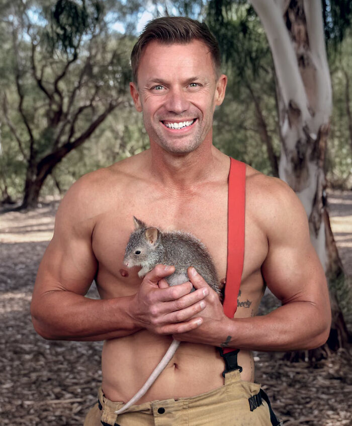 Shirtless Australian firefighter holding a small animal in the 2027 firefighters calendar
