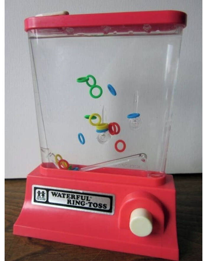 A vintage red and clear plastic Tomy Waterful Ring-Toss toy, a nostalgic game from childhood.