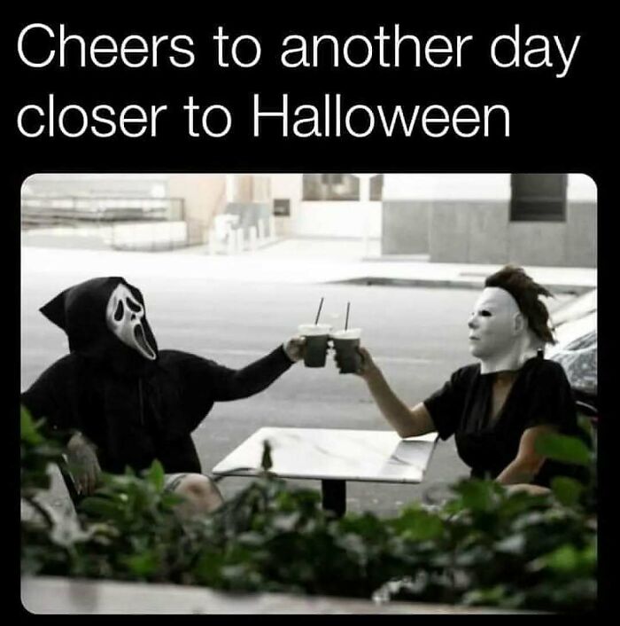 Spooky season meme of Ghostface and Michael Myers clinking iced coffee drinks outdoors.