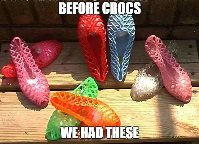 Nostalgic colorful plastic jelly shoes displayed on wooden steps.