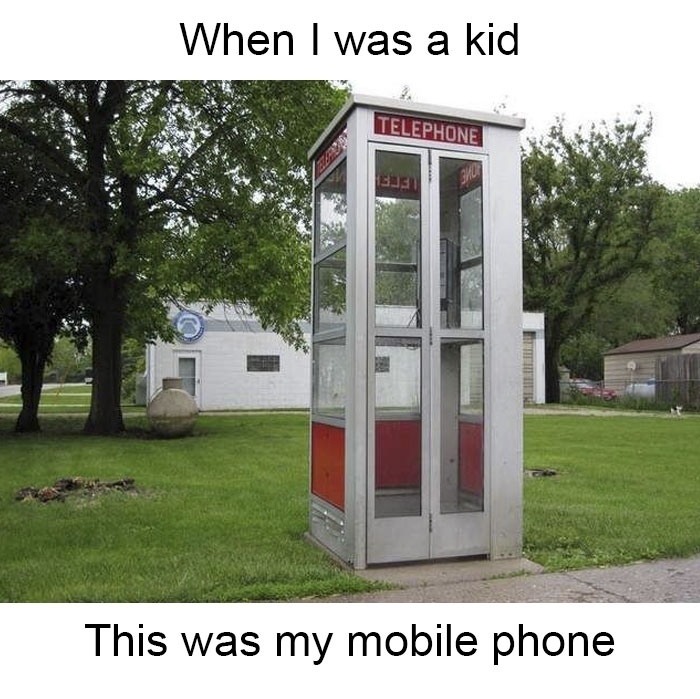 Nostalgic old outdoor telephone booth on a grassy lawn