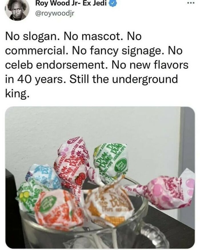 A glass mug filled with assorted colorful Dum Dums lollipops bringing back nostalgic memories