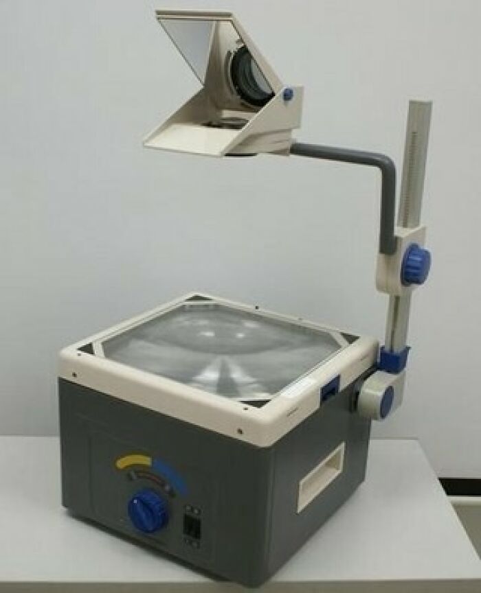 A nostalgic vintage school overhead projector sitting on a white table
