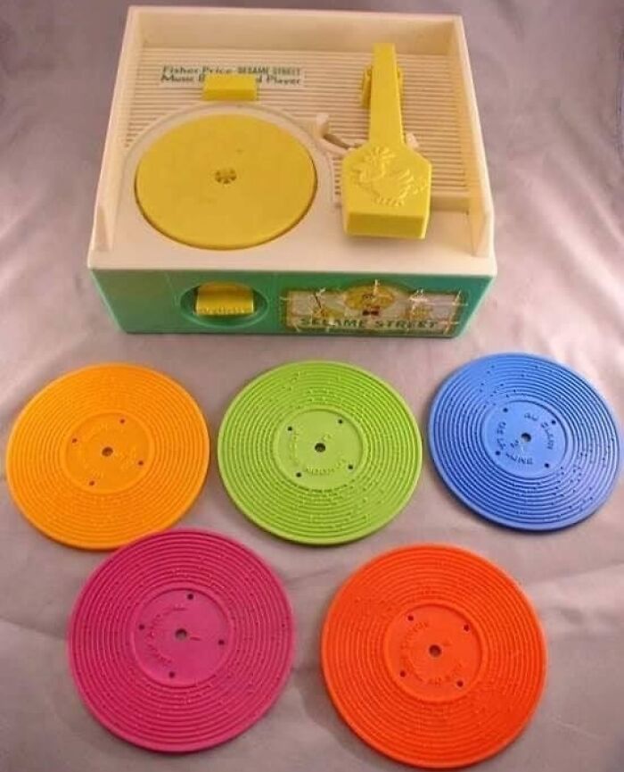 Nostalgic vintage Fisher-Price record player toy with five colorful plastic records.