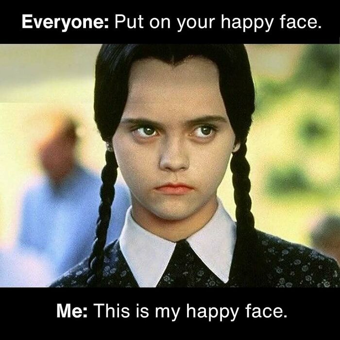 Spooky season meme with Wednesday Addams sternly claiming her unsmiling face is her happy face