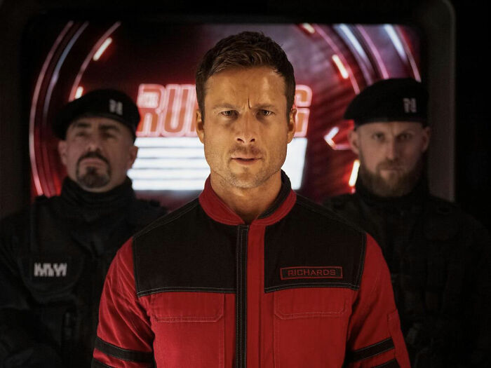 Glen Powell as a Hollywood Star in a futuristic military uniform