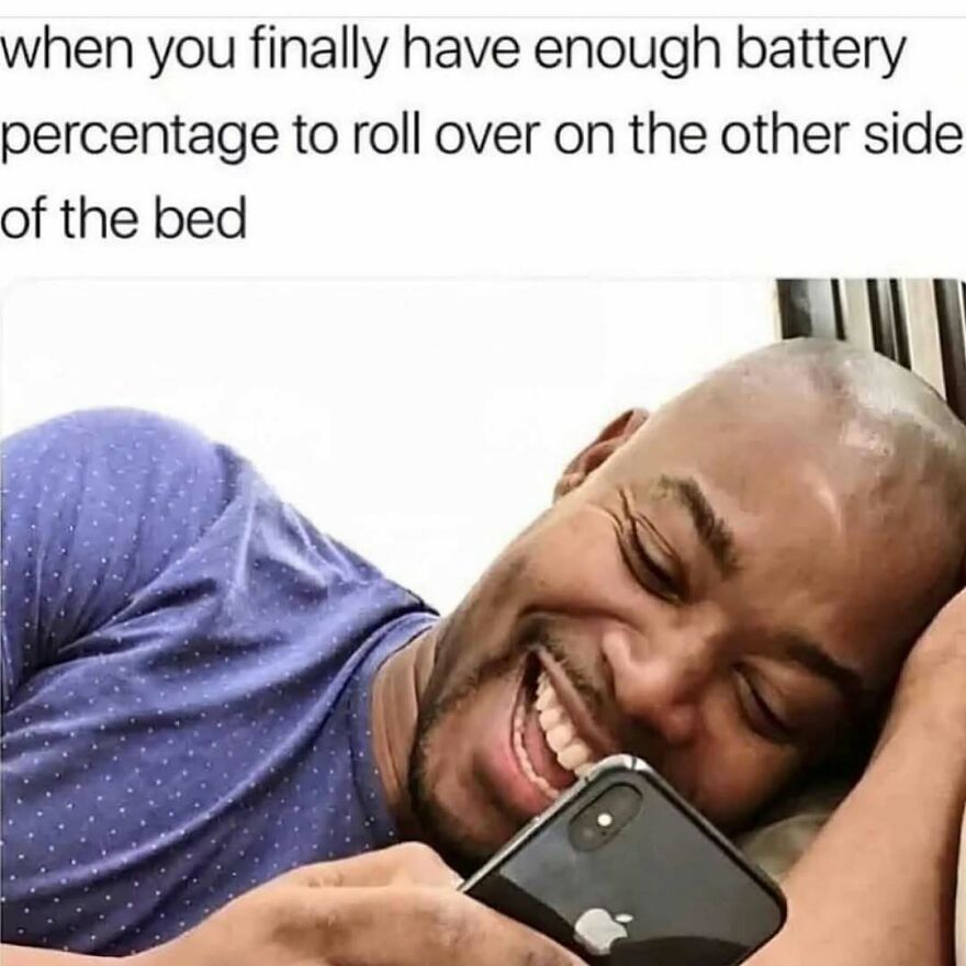 Out-of-context pics meme of a smiling man in bed holding his phone.