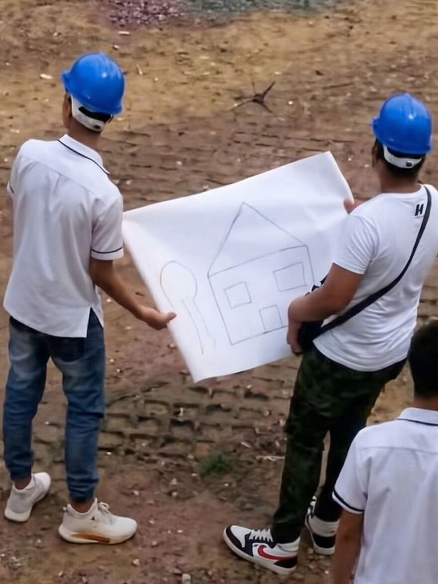 Out-of-context pics show construction workers looking at a simple child drawing of a house like a serious blueprint.