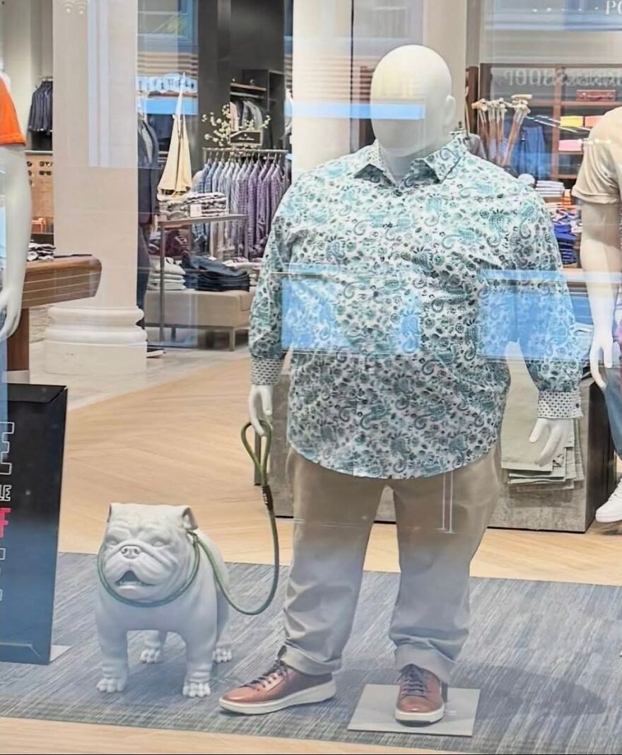A plus-size mannequin holding a bulldog statue on a leash, an example of out-of-context pics.