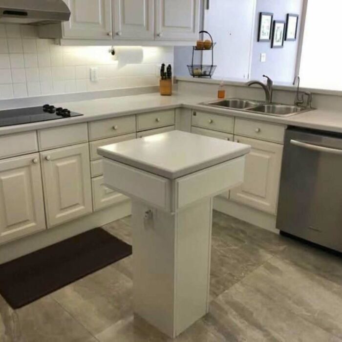 A kitchen with a tiny and impractical DIY project kitchen island in the center of the room.