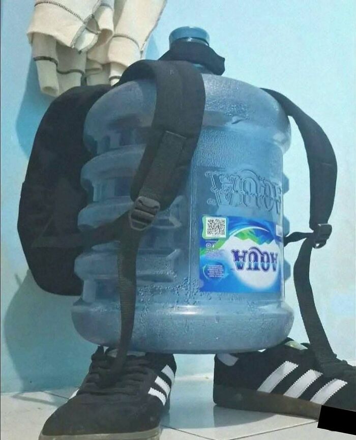 A large water jug wearing a backpack and shoes, making for amusing posts.