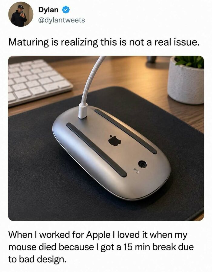 Silly post featuring an Apple Magic Mouse charging upside down on a desk.