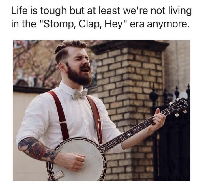 Bearded man playing banjo with caption about no longer living in stomp clap hey era