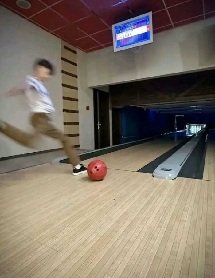 Hilarious pics of a person attempting to kick a bowling ball down an alley lane like a soccer ball