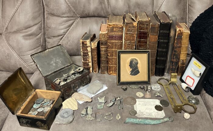 Collection of old books, coins, and historic artifacts gathered by an antique lover