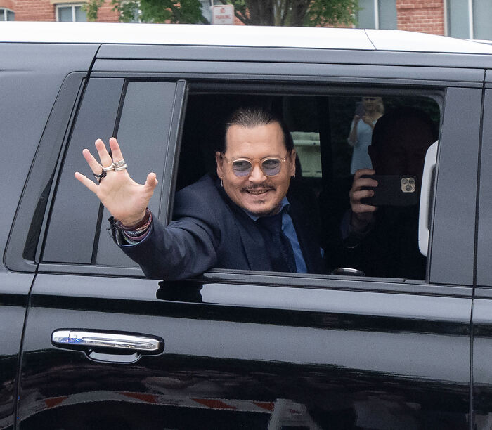 Johnny Depp waving from a car window during the Amber Heard lawsuit trial