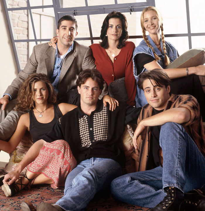 The original main cast of Friends posing together in a studio promotional photo shoot.